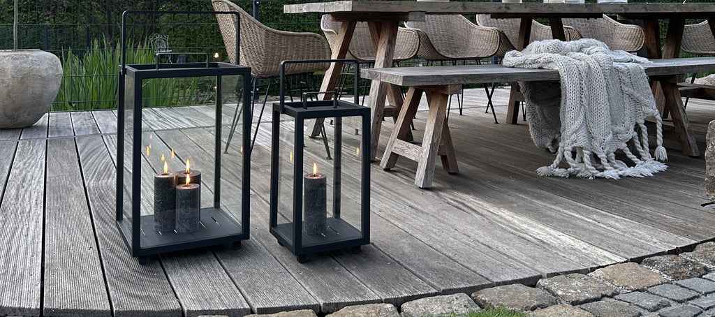 Outdoor lanterns in black with different heights, liten with multiple grey candle lights