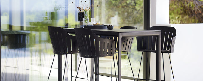 Modernes Bartisch-Set mit passenden Barhockern, das sich durch ein schlankes Design und minimalistische Ästhetik auszeichnet, perfekt für gesellige Zusammenkünfte und Entspannung.