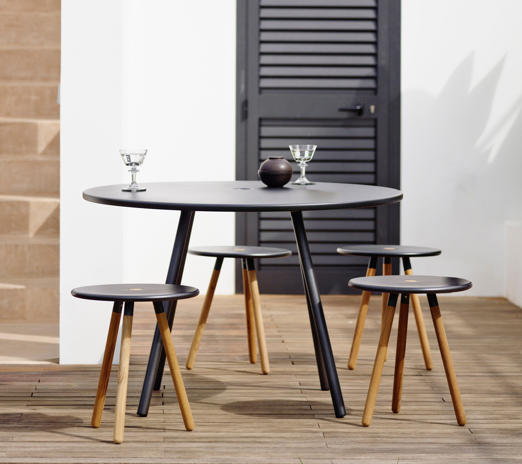 Modernem schwarzes Tisch mit passenden Barhockern in einem stilvollen Lounge-Ambiente.