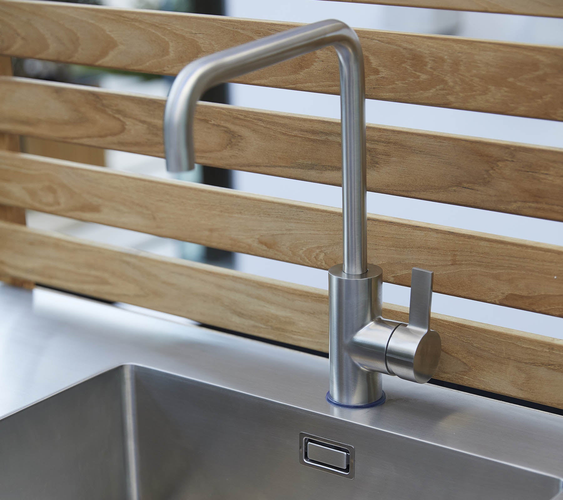 Elegante Wasserhahn aus Edelstahl mit einem schlanken Design und einer Einhebelbedienung, über einem modernen Waschbecken positioniert.