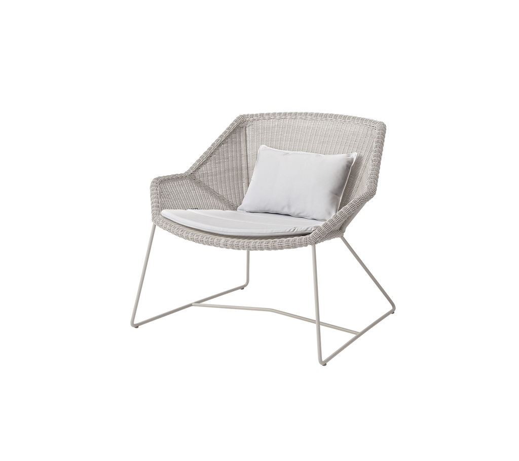 Moderne weiße Stuhl mit einem weißen Kissen in einer Lounge-Umgebung.