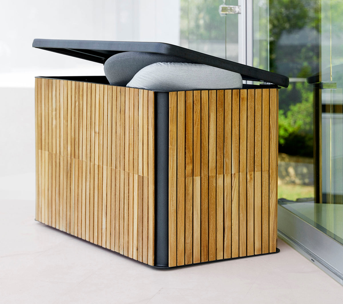 Stylische Aufbewahrungsbox mit einem lamellenförmigen Holzaußen und einem klappbaren Deckel, ausgestattet mit einer gepolsterten Oberseite für zusätzlichen Komfort und Funktionalität.
