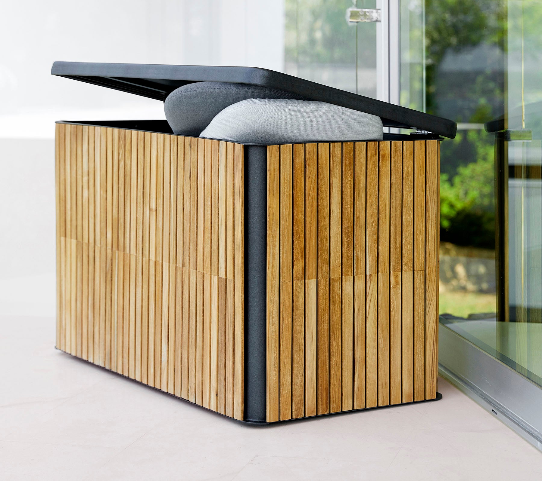 Stylische Aufbewahrungsbox mit einem lamellenförmigen Holzaußen und einem klappbaren Deckel, ausgestattet mit einer gepolsterten Oberseite für zusätzlichen Komfort und Funktionalität.