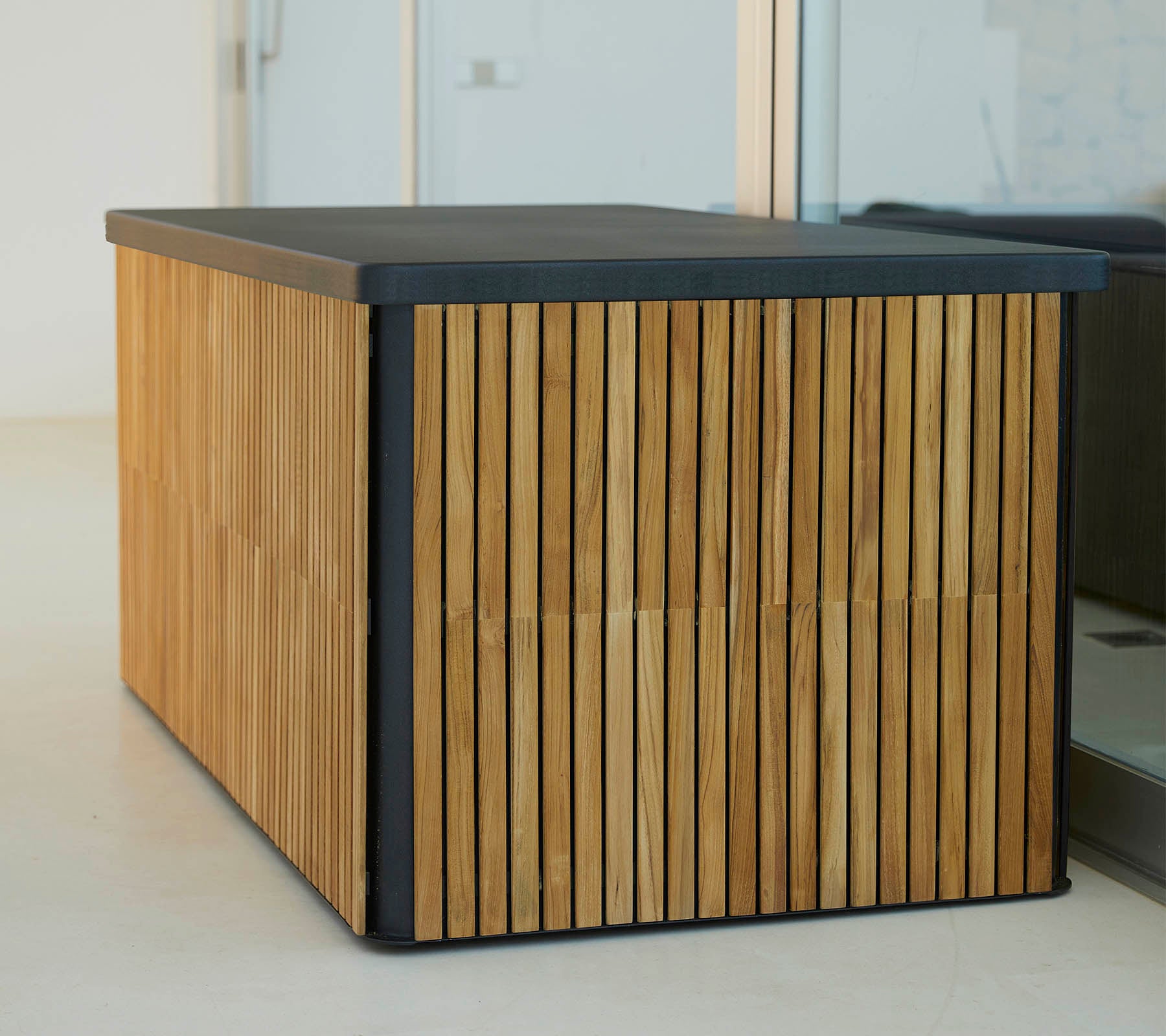 Ein moderner Holztisch mit vertikalen Lamellen an den Seiten und einer eleganten, dunklen Tischplatte, die ein stilvolles und funktionales Design bietet.