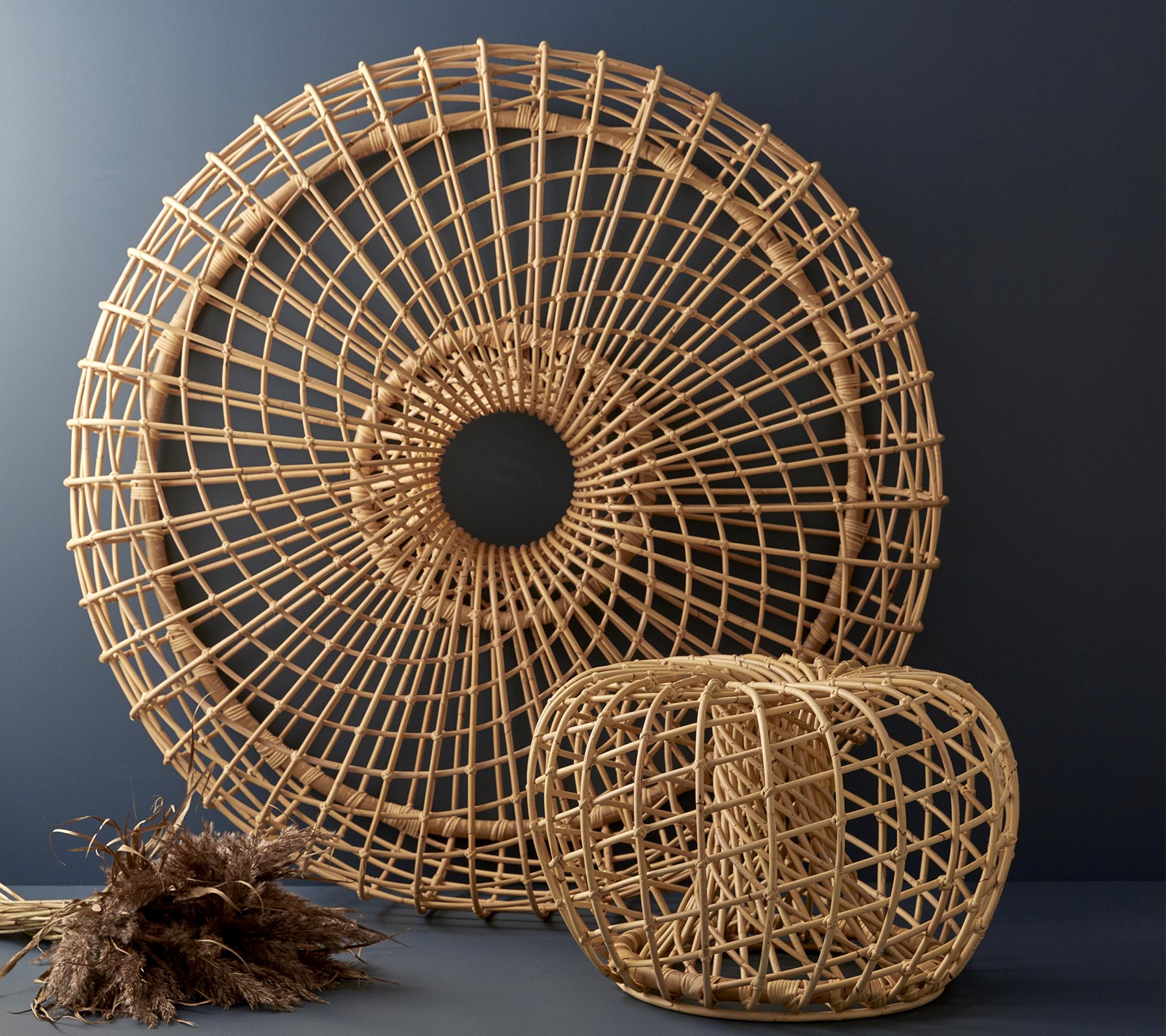 Gewebte Rattan-Dekorationsstücke in kreisförmigem und kubischem Design, die komplexe Muster und natürliche Texturen präsentieren.