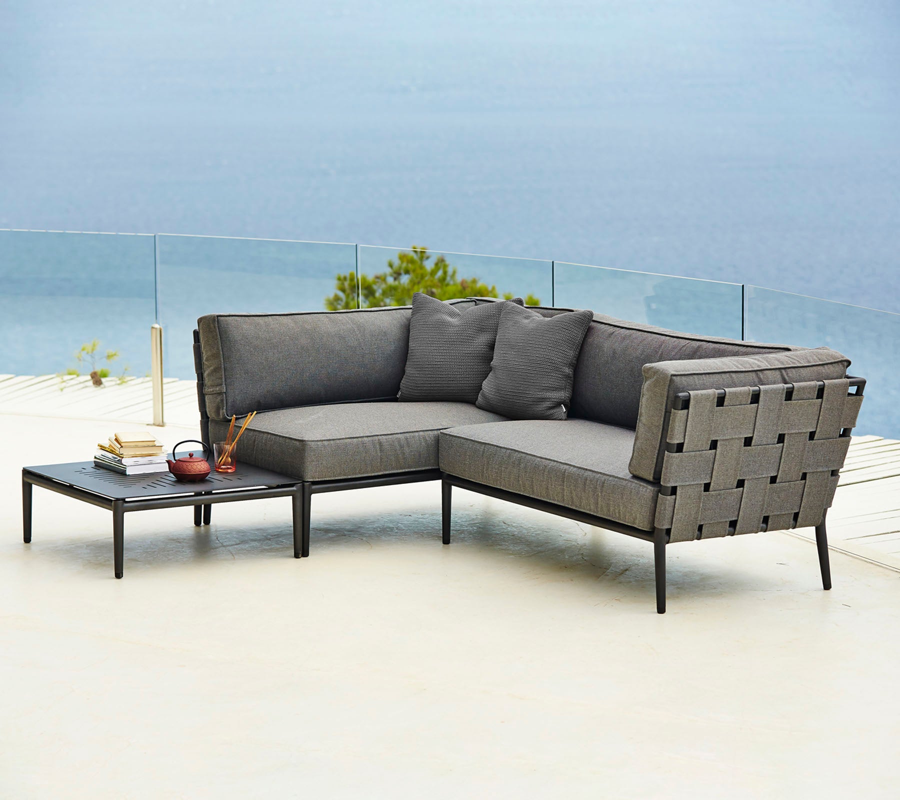 Stylische Outdoor-Sectionalssofa mit bequemen Kissen und einem passenden Beistelltisch, perfekt zum Entspannen und Genießen.