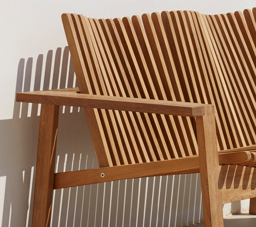 Seitenansicht eines stylischen 2-Sitzer Sofas mit einem Laminetrückenlehne und Holzarmlehnen, das ein modernes Design zeigt.