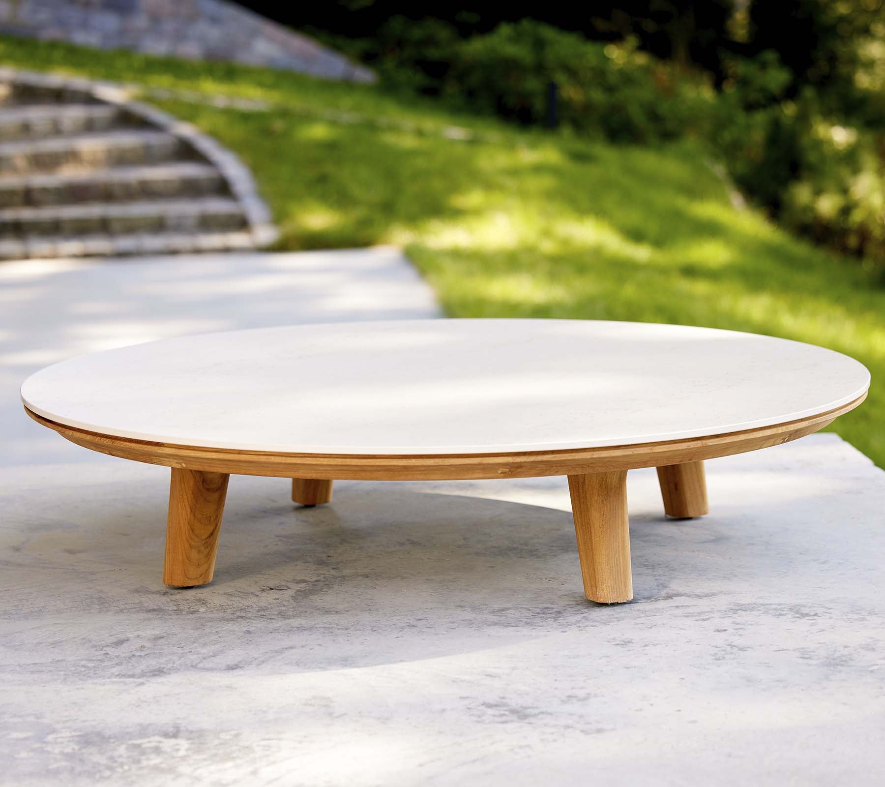 Modern runder Couchtisch mit glatter Oberfläche und Holzbeinen, ausgestattet mit einem minimalistischen Design, das für verschiedene Umgebungen geeignet ist.