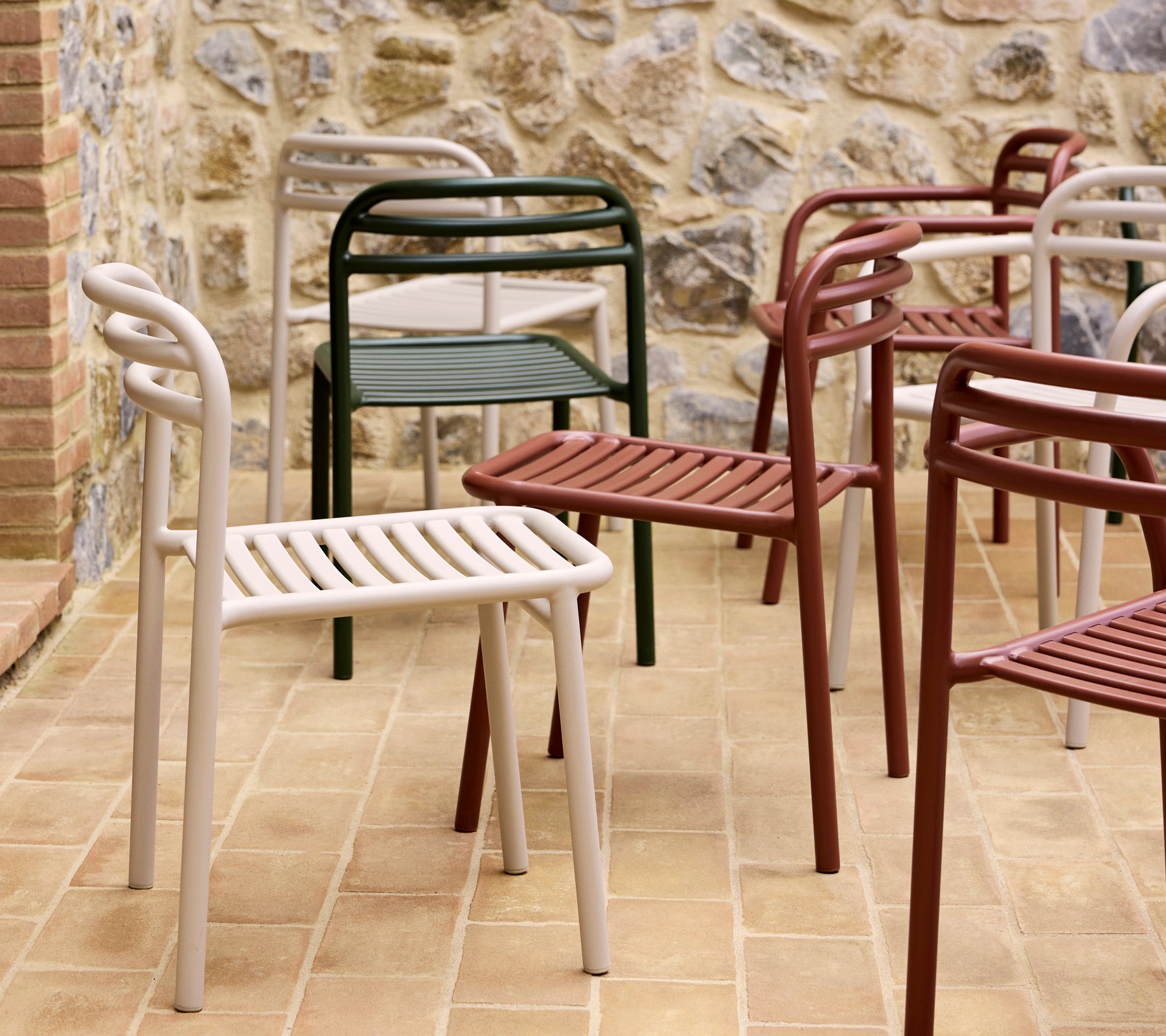 Eine Sammlung bunter Bliss-Stühle in verschiedenen Farbtönen, die ein modernes, minimalistisches Design mit lamellenartigen Sitzen und geschwungenen Rückenlehnen zeigt.