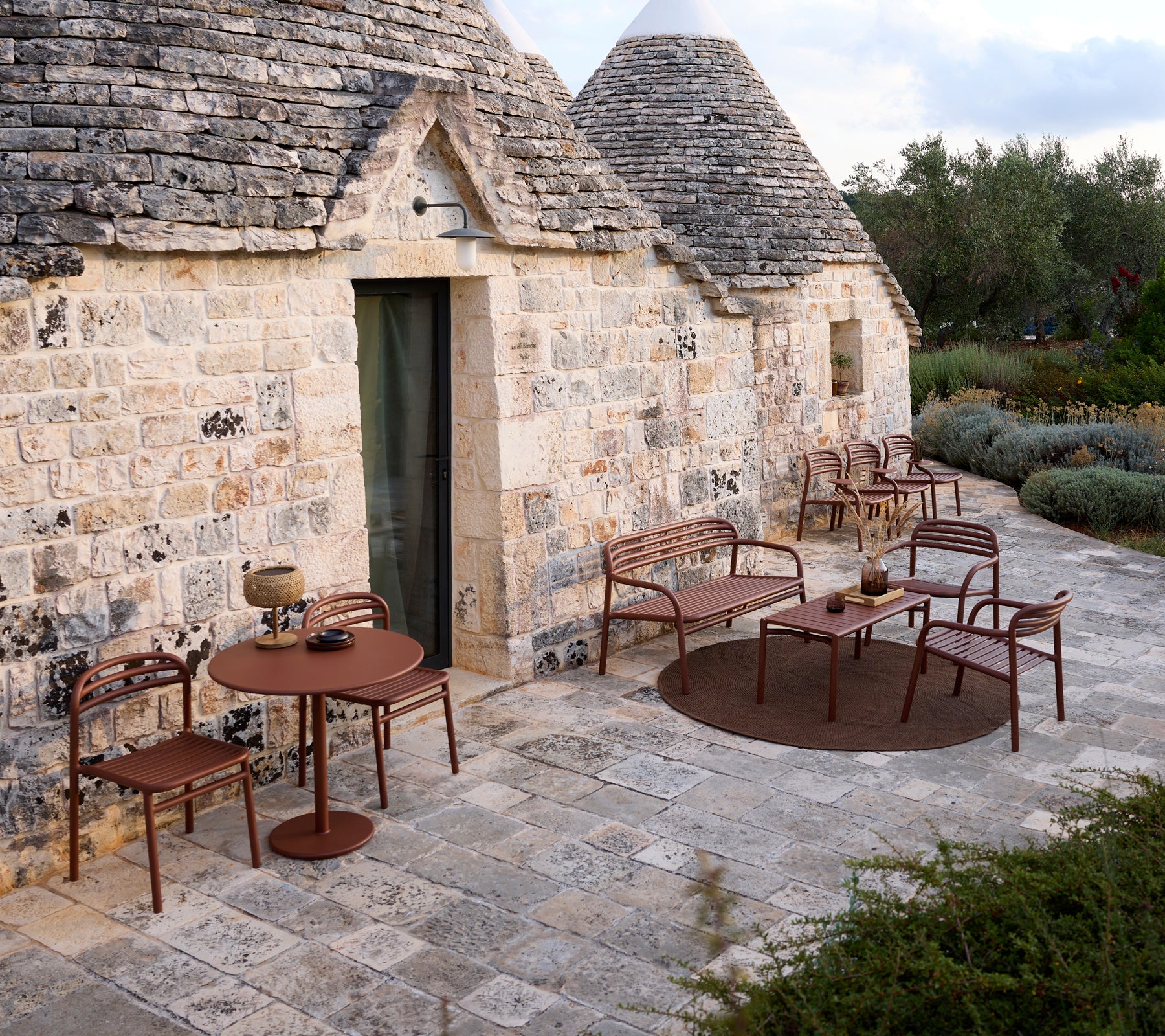 Außenbereich mit einem braunen Tisch und Stühlen in modernem Design.