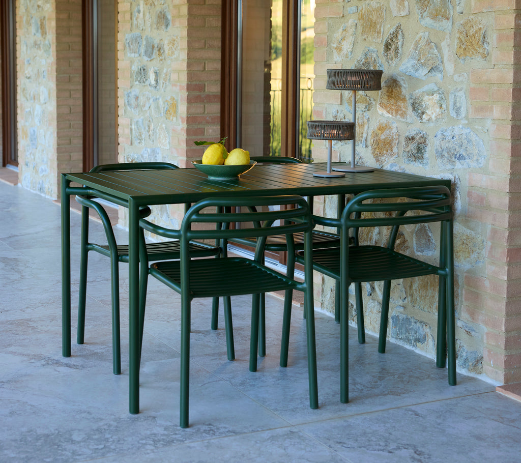 Bliss rechteckiger Tisch mit Bliss-Stühlen und einer Illusion-Lampe, die mit dekorativen Zitronen und einem stilvollen Stein-Hintergrund ausgestattet ist.