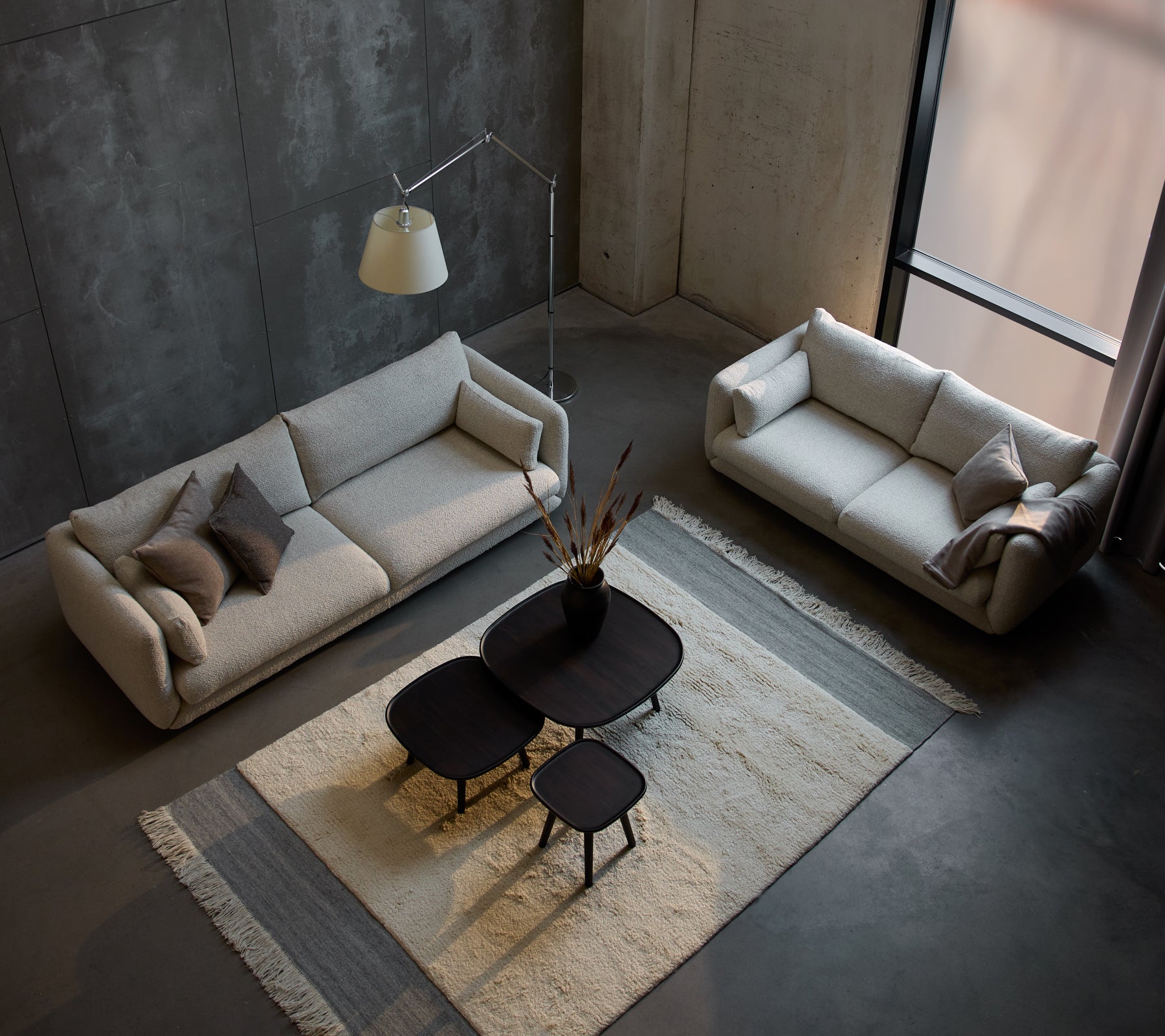 Ein modernes Sitzbereich mit einem Bloom 3-Sitzer Sofa, einem kleineren 3-Sitzer Sofa und stilvollen Pace Couchtischen auf einem strukturierten Teppich.