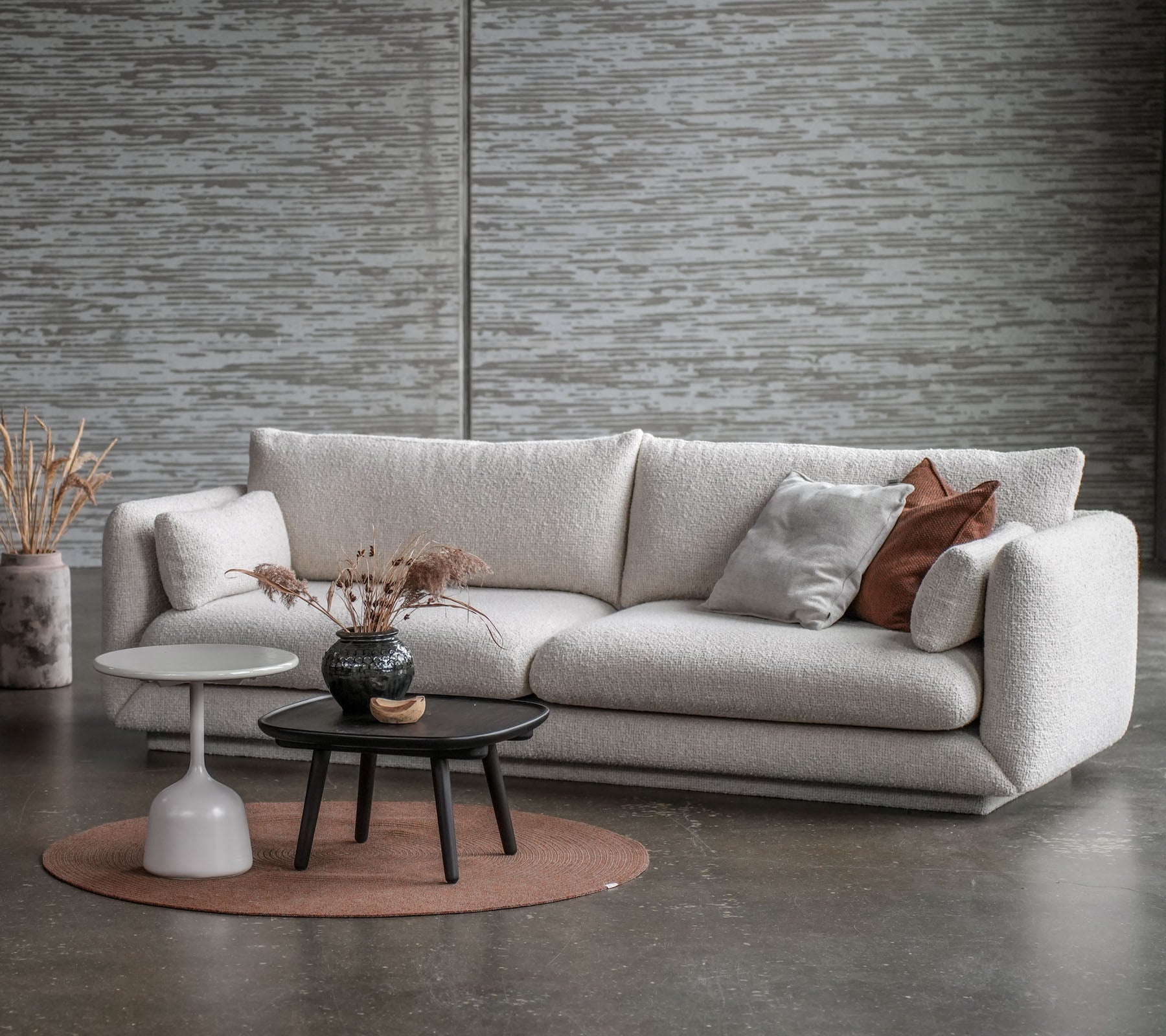 Ein stilvoller Sitzbereich mit einem hellen Sofa, einem runden Couchtisch und dekorativen Elementen in sanften Farben.