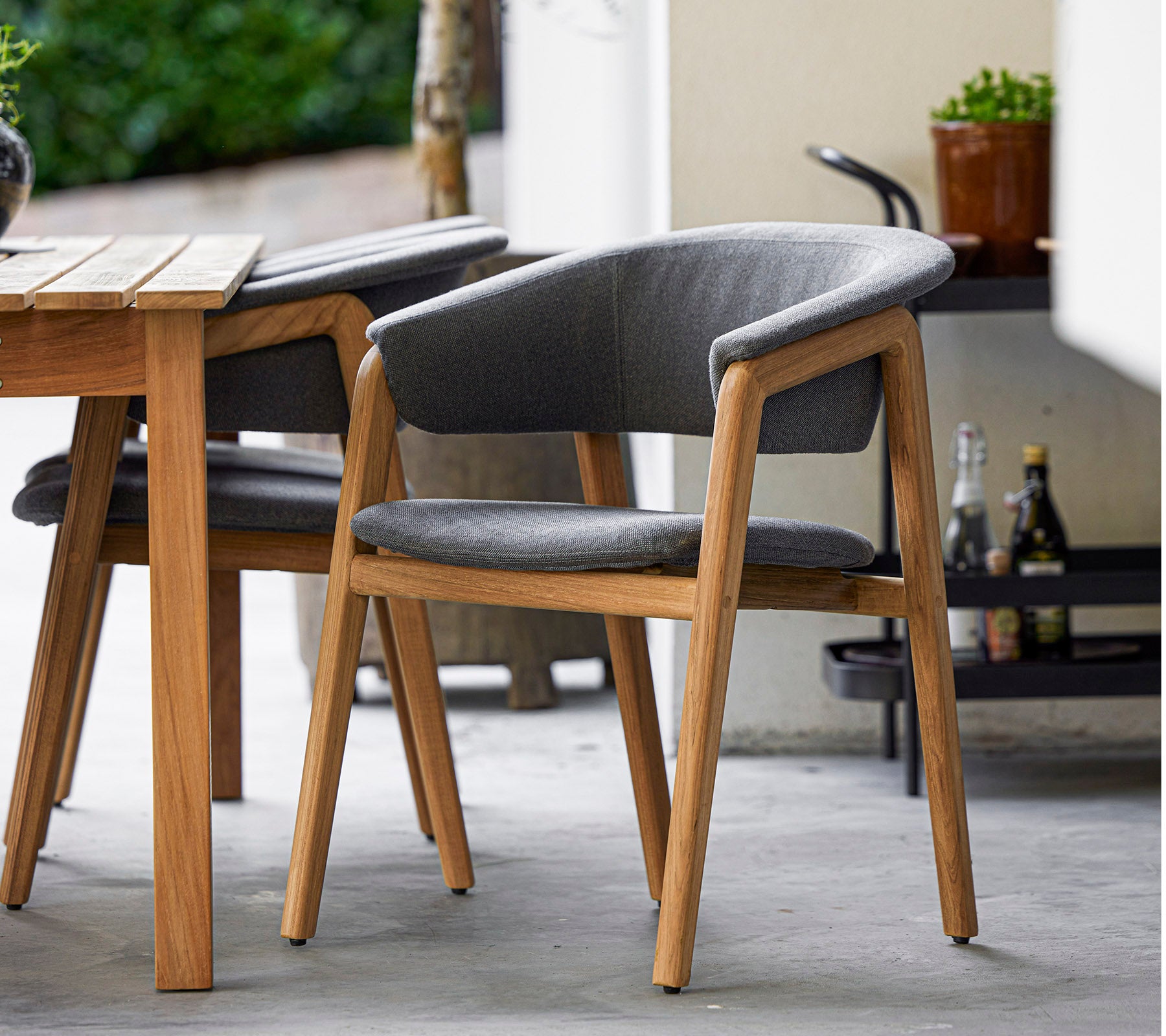 Stylischer Stuhl mit einem Holzrahmen und grauem Bezug, entworfen für Komfort und Eleganz, perfekt für moderne Einrichtungen.