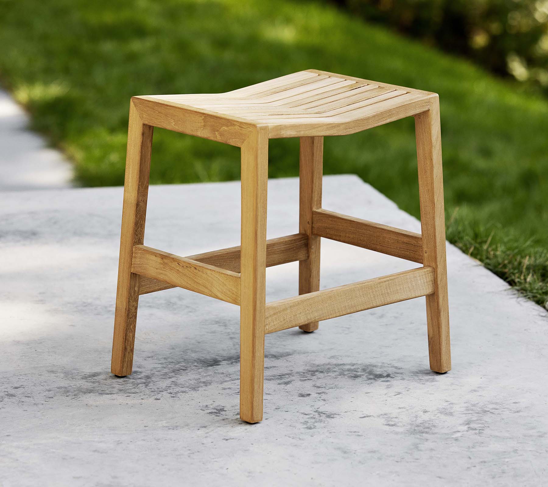 Ein Holzklapphocker mit einem lamellen Sitz und stabilen Beinen, entworfen für vielseitige Sitz- oder dekorative Zwecke.