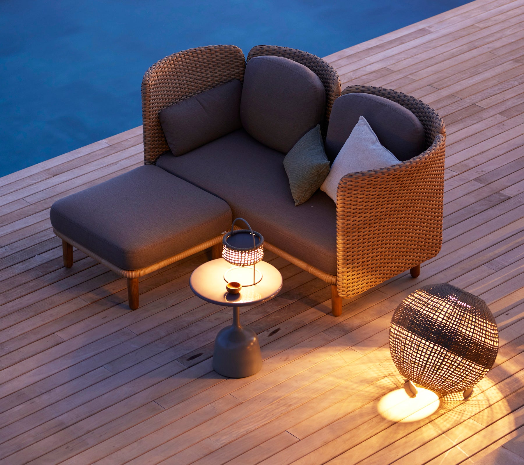 Gemütlicher Sitzbereich mit einer stilvollen Illusionslampe auf einem runden Beistelltisch und modernen Akzentmöbeln, warm beleuchtet in sanftem Licht.