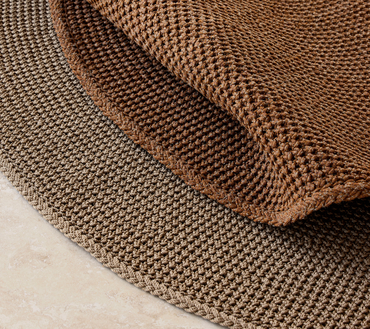 Gestrickter Teppich mit einem Durchmesser von 200 cm, der ein strukturiertes braunes Design und ein geschichtetes Aussehen aufweist.