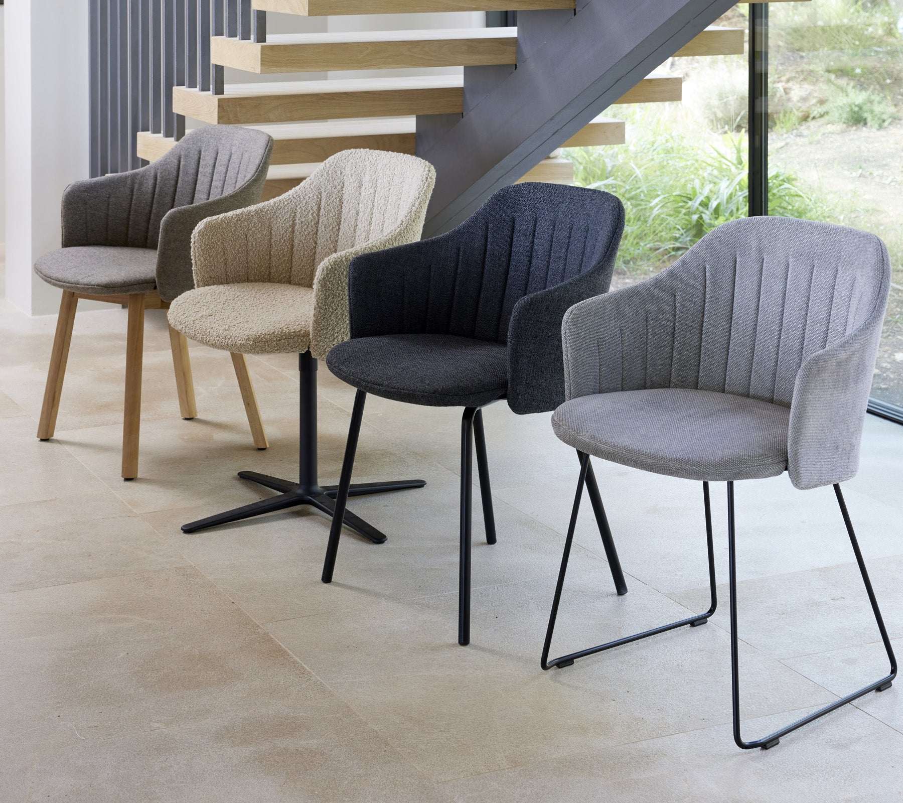 Vier moderne Stühle in verschiedenen Farben und Stilen, präsentiert in einem zeitgemäßen Umfeld, die ihre einzigartigen Designs zeigen.