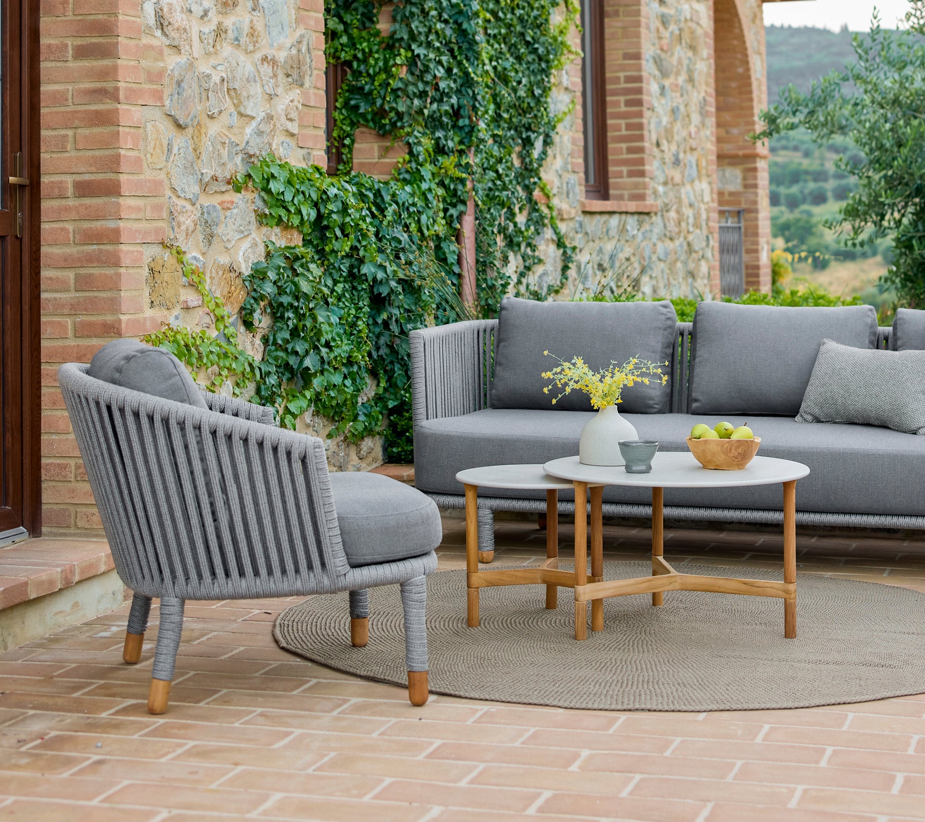 Ein stilvoller Lounge-Sessel und Kaffeetisch-Set mit modernem Design, umgeben von Grünpflanzen und einer warmen, einladenden Atmosphäre.