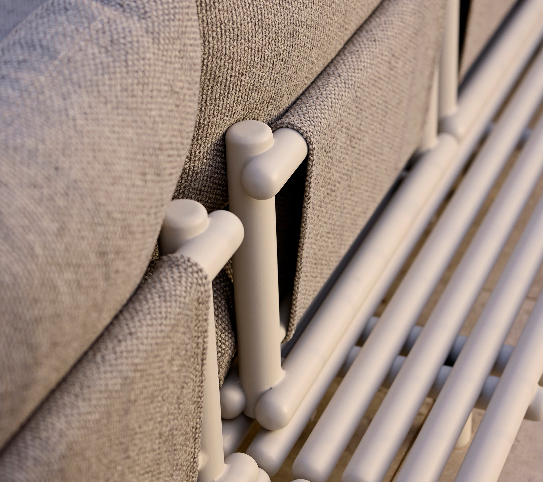 Nahaufnahme einer Lounge-Plattform mit Aluminiumstreben und einem strukturierten grauen Stoff, der moderne Designelemente hervorhebt.