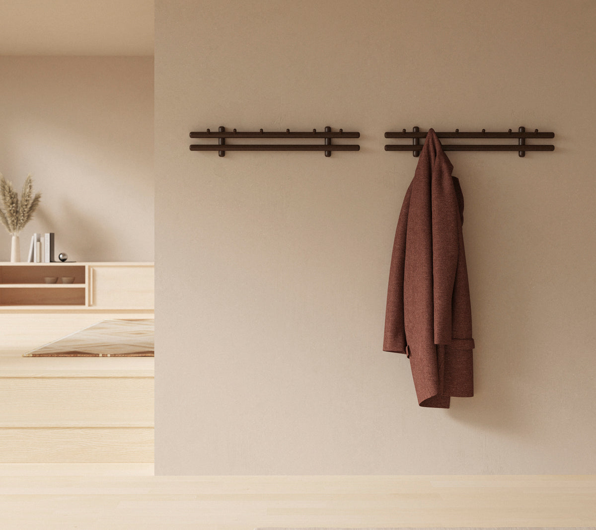 Ein minimalistisches Wanddisplay mit Holzstäben, die einen Mantel und eine Sammlung von Lappen halten, wodurch die rustikale Dekorästhetik verbessert wird.