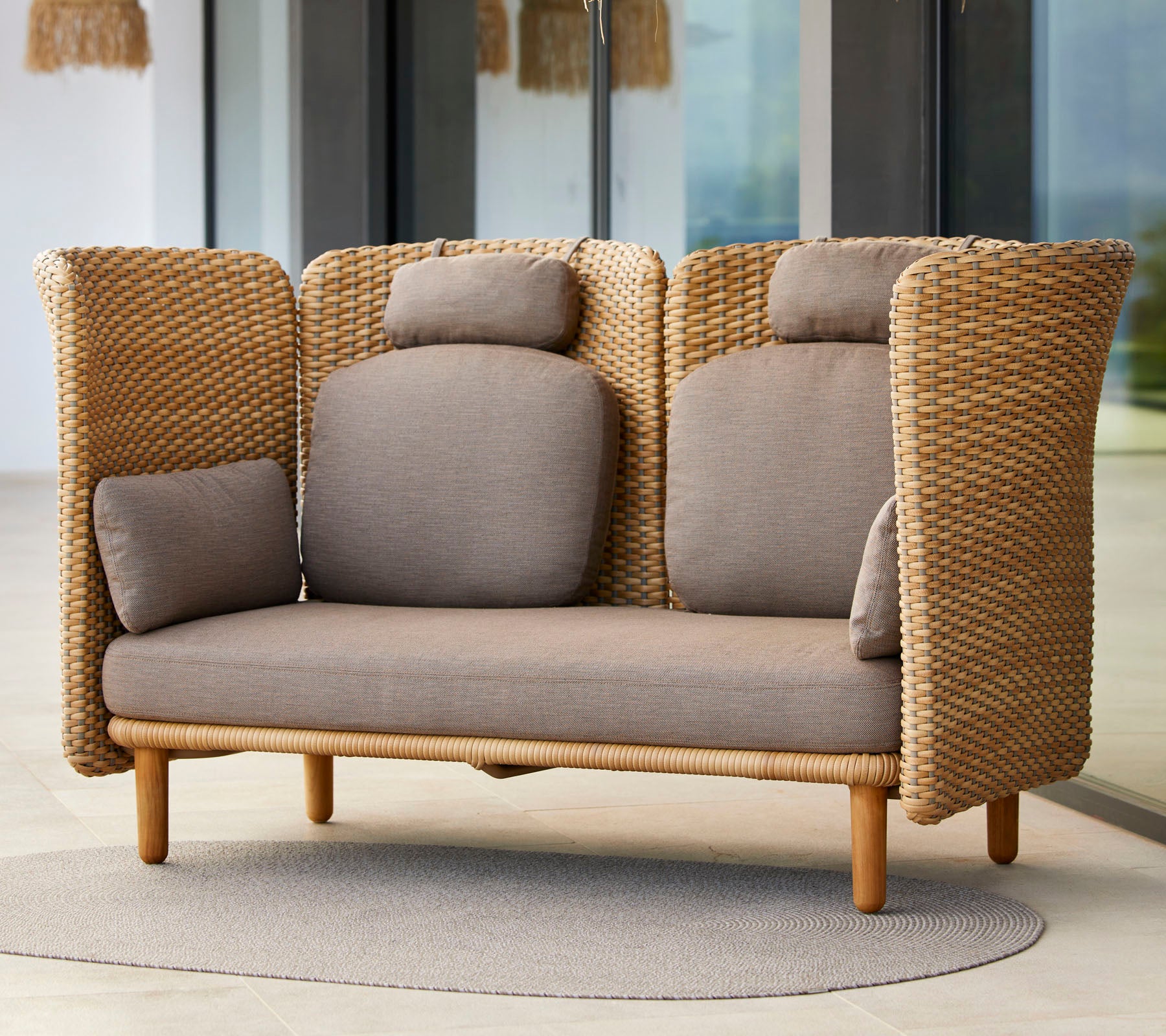 Stilvolles Zweisitzer-Sofa mit gewebter Textur, das über bequeme Kissen und ein natürlicher Holzfuß verfügt, ideal zur Entspannung.